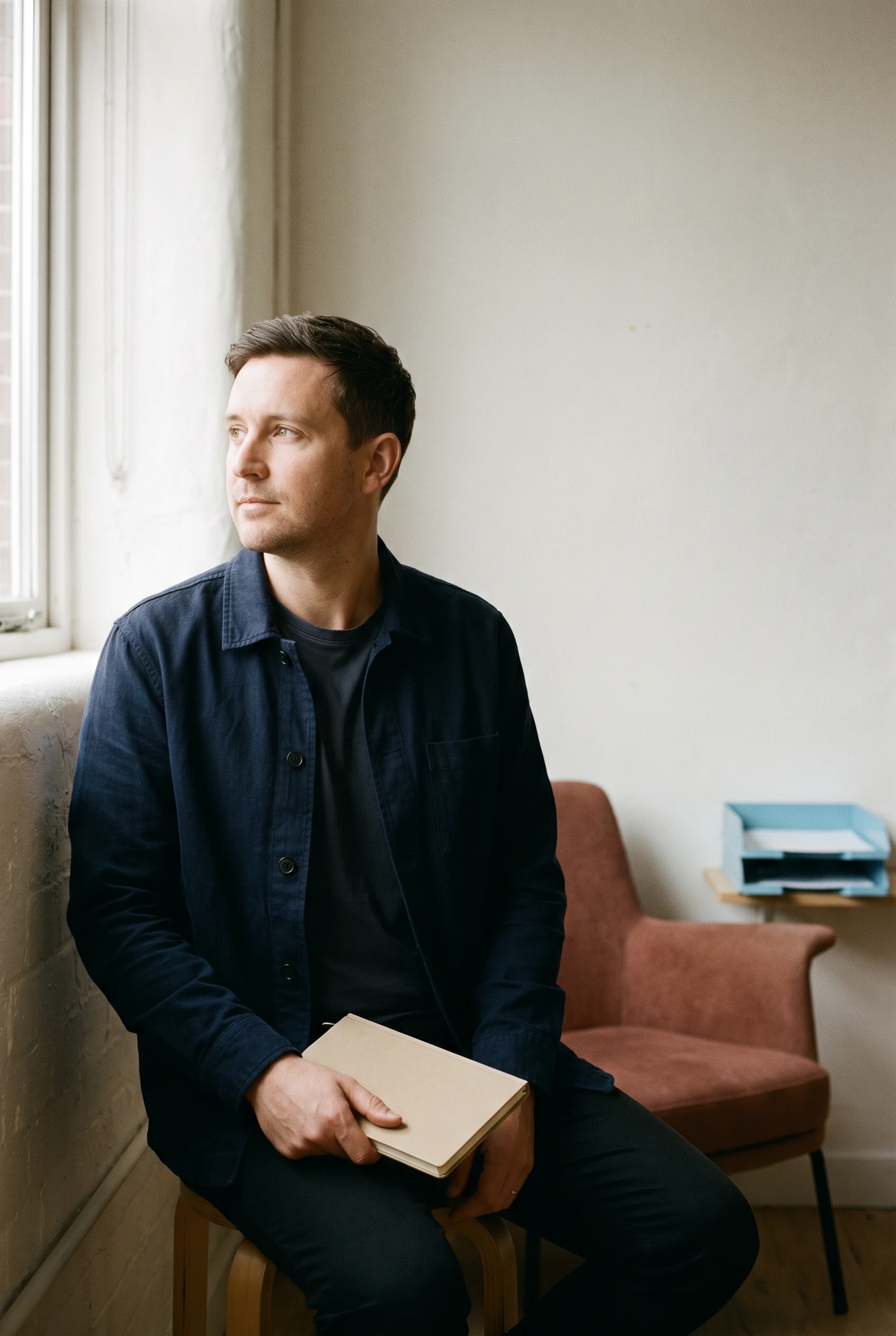 Thoughtful professional holding an unbranded notebook