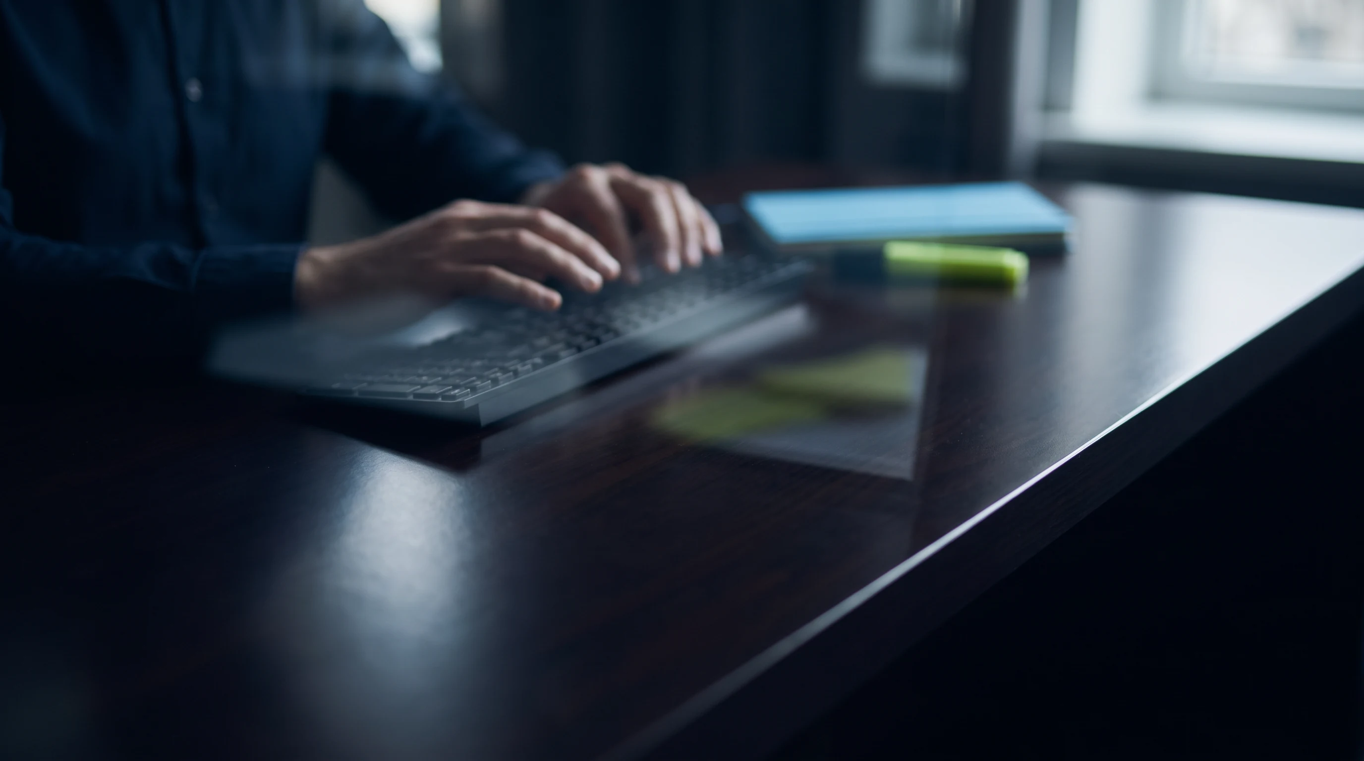 Keyboard and reflection on a dark desktop